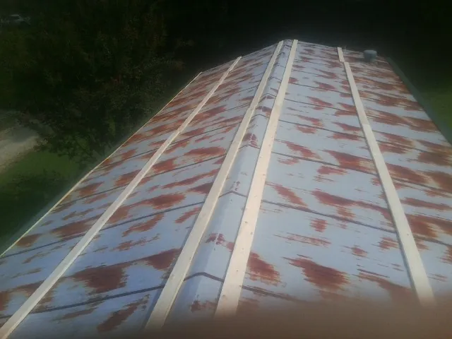 Rusted metal roof panels with new wood purlins before replacement — Storm Damage Roof Repair in Chalmette by Roofing Brothers