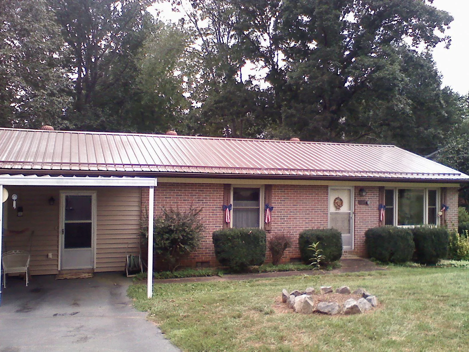 Bronze metal roof and carport on a brick ranch home — Roof Repair work by our crew in Chalmette
