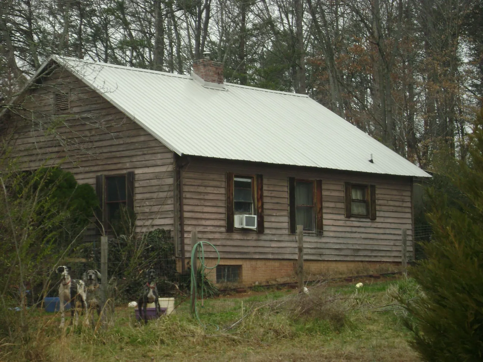 White metal roof on an old wood sided farmhouse, from a Metal Roof Installation job in Chalmette